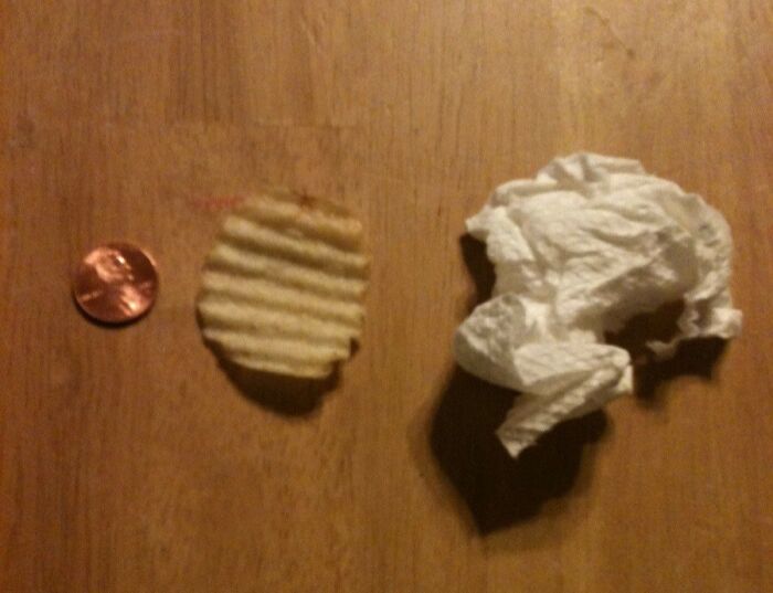 Weird yet cute Valentine's gift with a penny, chip, and tissue on a wooden table.