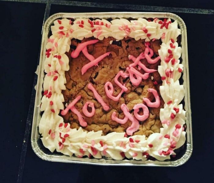 Weird yet cute Valentine's cookie cake with "I Tolerate You" written in pink icing.