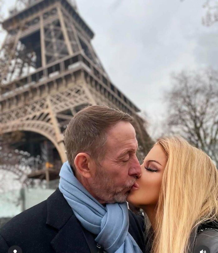 Couple kissing in front of the Eiffel Tower, showcasing an example of a Photoshop airbrush effect.