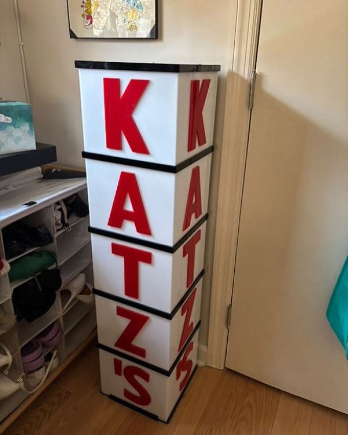 Katz's deli sign discovered in Stooping NYC, featuring large red letters on a tall, white column in a room corner.