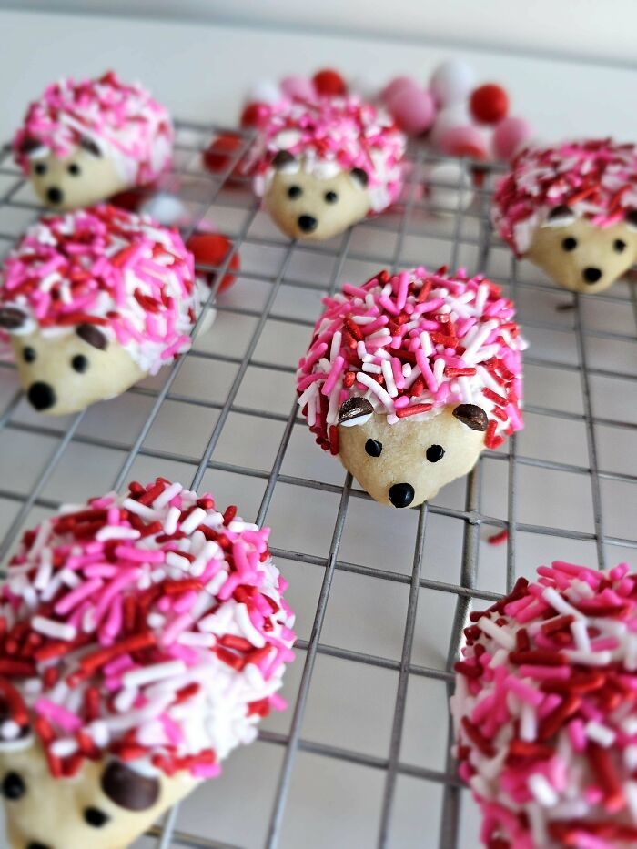 Cute hedgehog-shaped cookies decorated with pink and red sprinkles cooling on a wire rack, showcasing incredible bakes.