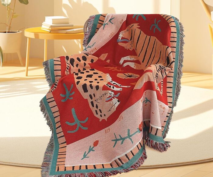 Colorful animal-patterned throw blanket on chair, showcasing 2025 interior trends in a sunlit living room.