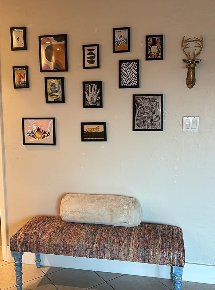 Gallery wall with eclectic art and a decorative bench, showcasing 2025 interior trends.