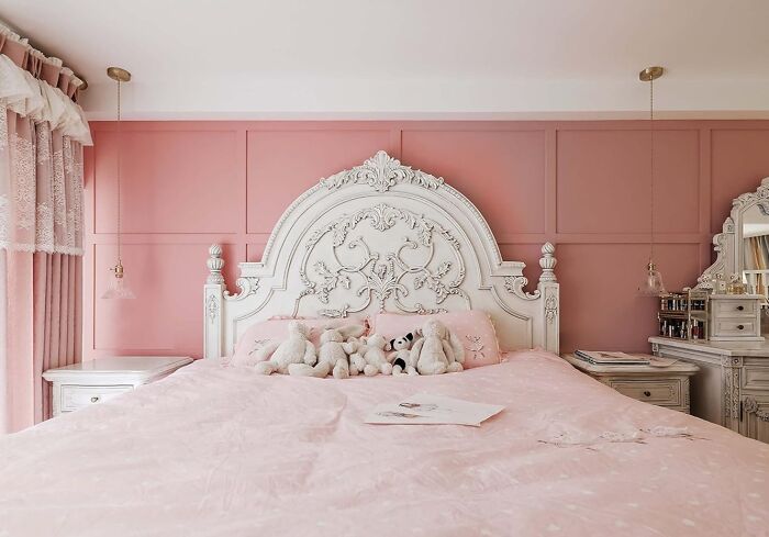 Elegant bedroom showcasing 2025 interior trends with ornate white headboard and soft pink decor.