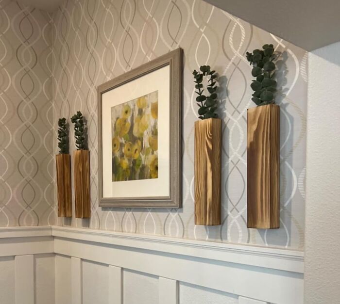 Wall art featuring yellow flowers and wooden planters with greenery, reflecting 2025 interior trends in home decor.