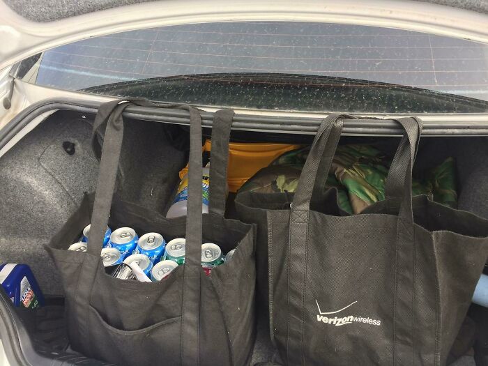 Reusable bags in a car trunk filled with groceries, showcasing grocery-shopping-hacks for efficient storage.