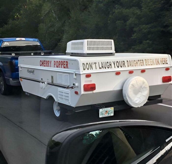 A humorous camper with a playful sign on the highway, reflecting a quirky Florida-Wild-Moments scene.
