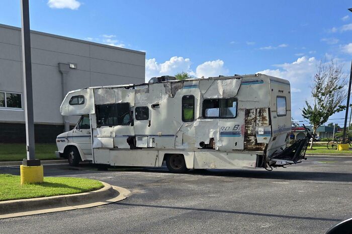 Damaged RV parked in a lot under a clear sky, Florida wild moments.