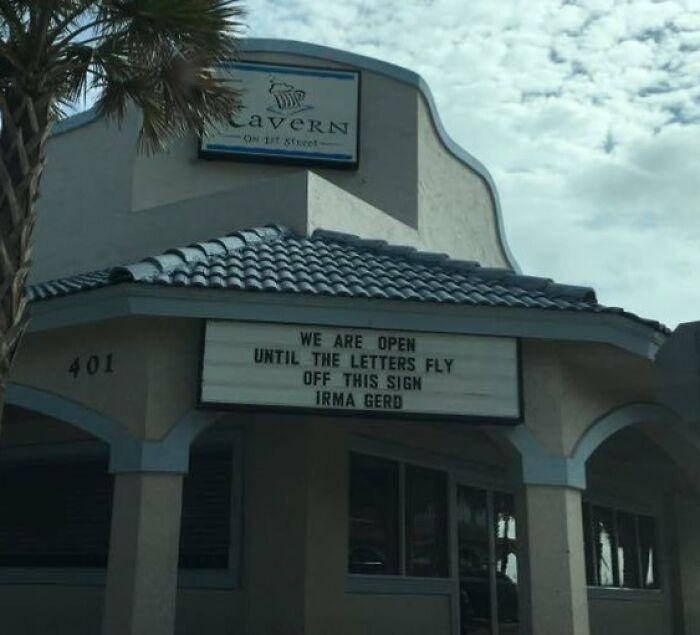 Sign on a Florida restaurant reads, "We are open until the letters fly off this sign, Irma Gerd," showcasing humor.