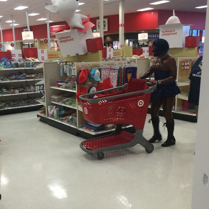Shopper in unique attire pushing a cart in a Florida store, capturing wild moments at the toy section.