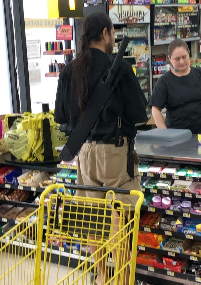 A man in a store with a sword on his back, interacting with the cashier, highlighting a unique Florida wild moment.