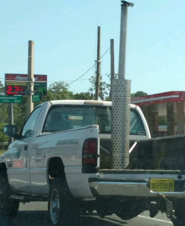 White truck in Florida with unique metal exhaust pipe, parked at a RaceTrac gas station.