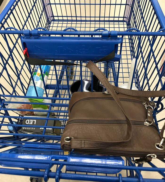 Blue shopping cart with groceries and a brown purse, showcasing grocery-shopping-hacks.