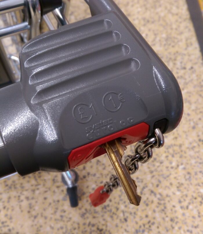 Coin inserted in a grocery cart lock, demonstrating a shopping hack for unlocking carts without using a coin.