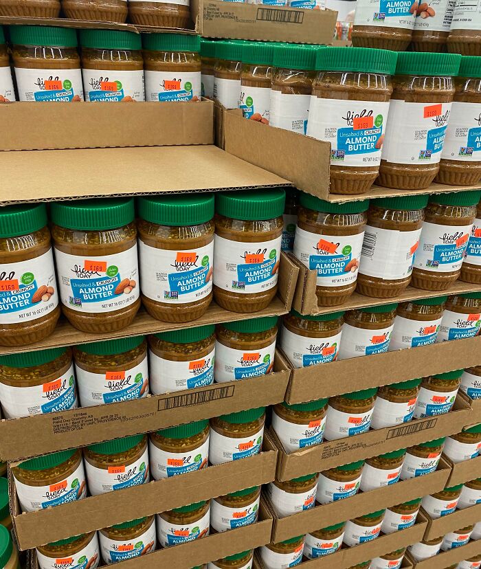 Almond butter jars stacked on grocery store shelves, illustrating grocery-shopping-hacks for bulk buying.