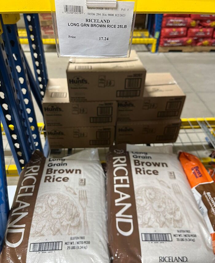 Bags of Riceland long grain brown rice with a price label, showcasing a grocery-shopping-hacks deal at a store.