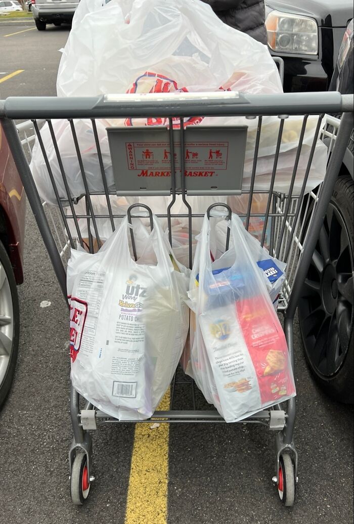 Shopping cart filled with bags in a parking lot, showcasing grocery-shopping-hacks for efficient packing.