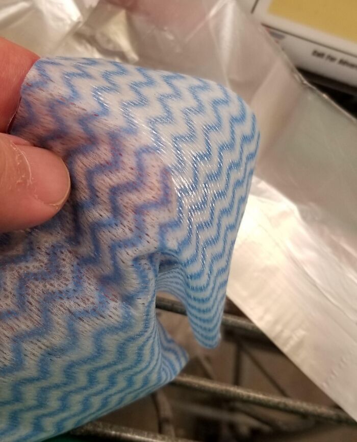 Close-up of a hand holding a blue cloth used for grocery shopping hacks.