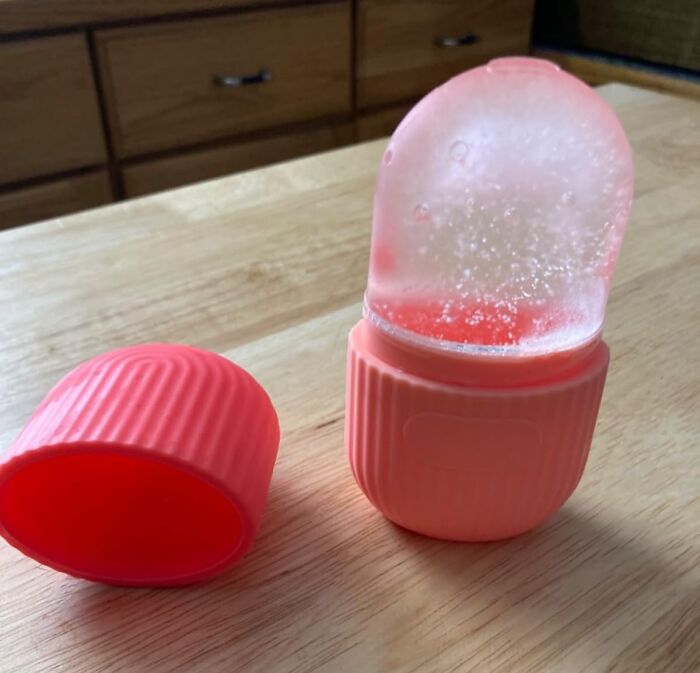 Small pink portable hand warmer on wooden table, an affordable item under $5 to save that coin.