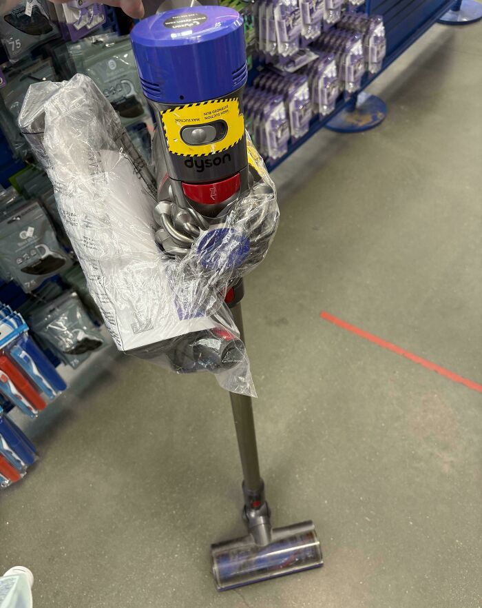Dyson cordless vacuum cleaner thrift store find displayed in plastic wrap on store floor with shelves in background