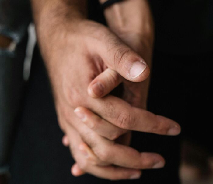 Close-up of two hands gently holding each other, symbolizing eye-opening moments of connection and support.