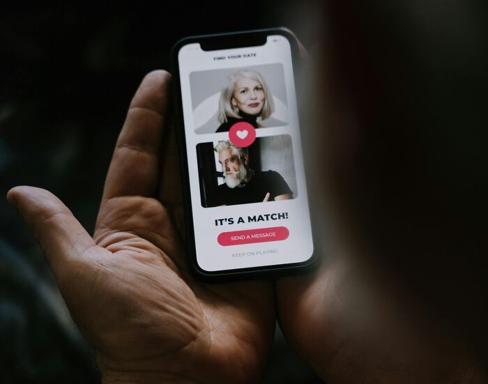 Person holding a phone showing a dating app match, highlighting eye-opening moments in online connections.