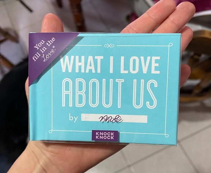 Hand holding a small book titled What I Love About Us, a creative idea for date night activities.