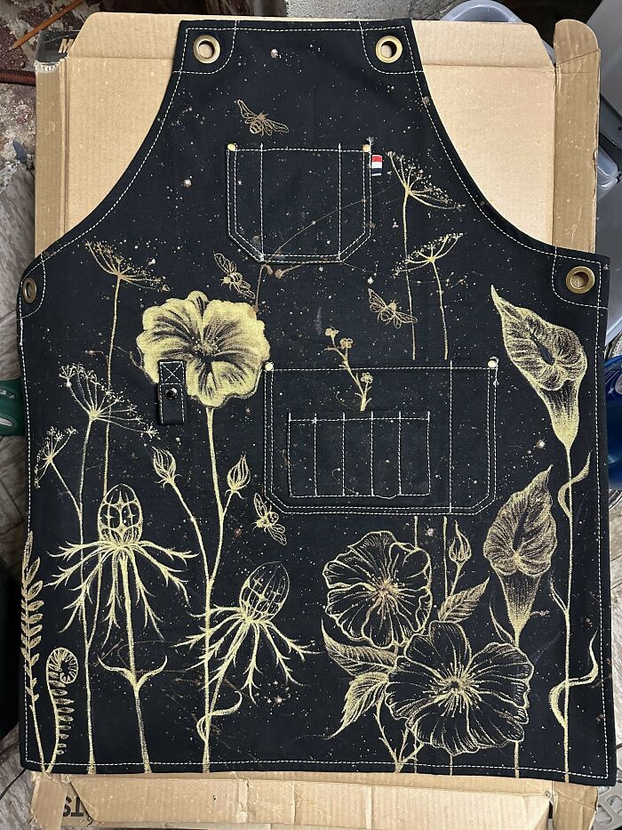 DIY project apron with floral design on black fabric background.