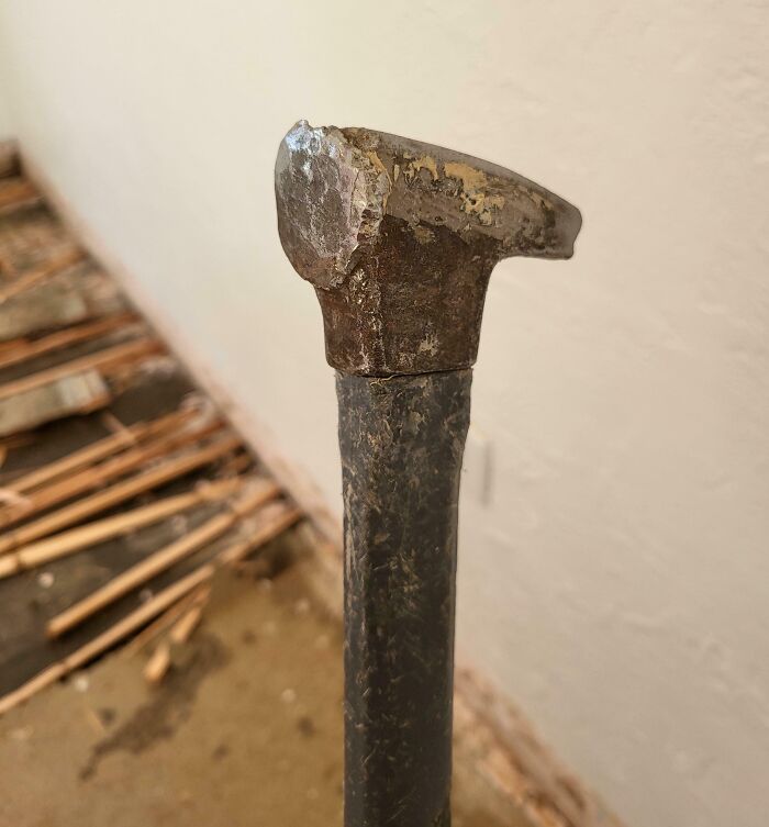 Worn-out hammer in a dilapidated space, symbolizing disillusionment with consumerism.