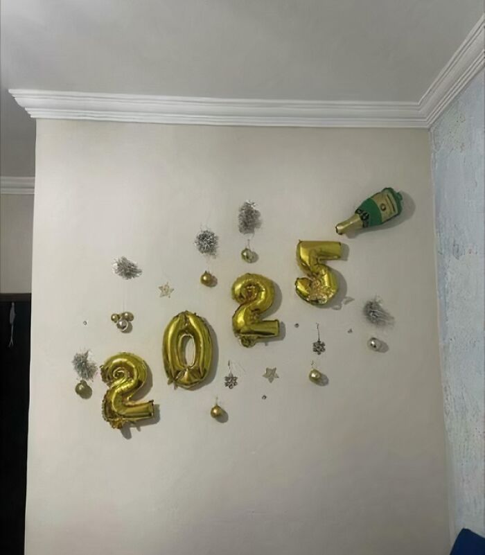 Gold balloons spelling "2023" with decorations, illustrating a critique of consumerism.