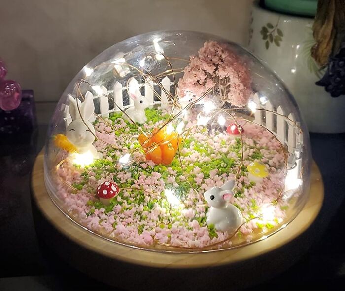 Artistic find: miniature garden under a glass dome with bunnies, flowers, and fairy lights.