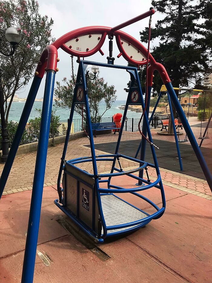 Accessible swing in a park near the sea, exemplifying Cities-Genius-Solutions for inclusivity.