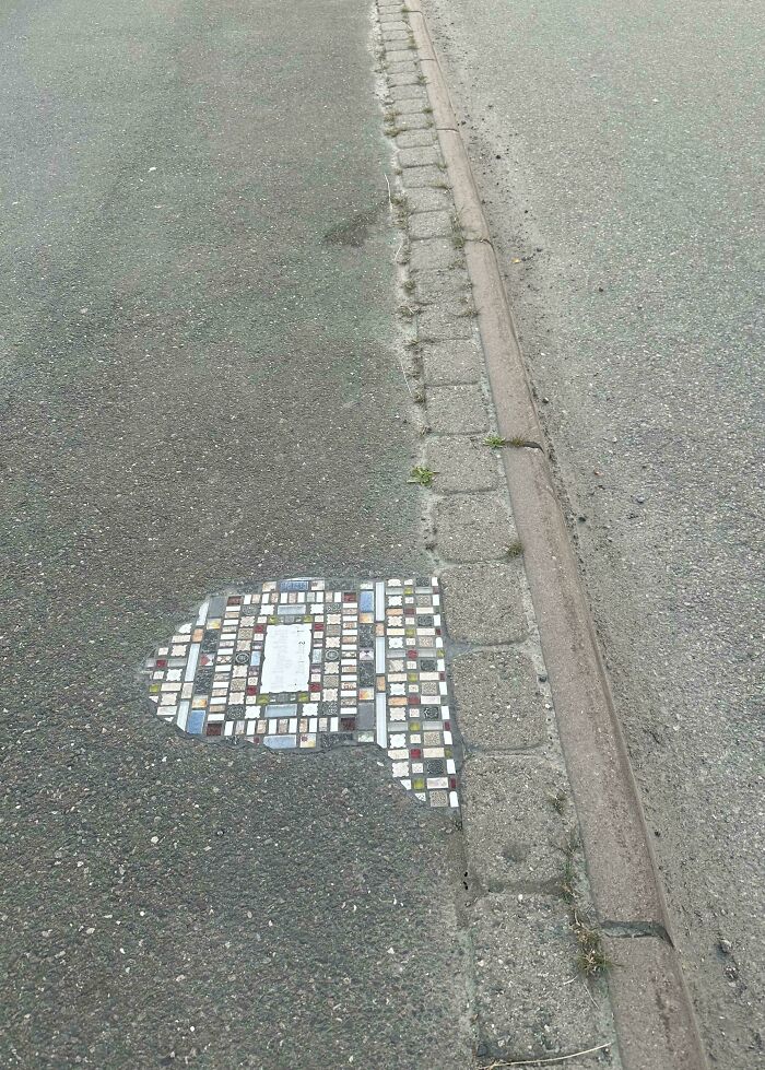 Colorful tile patch on a city sidewalk, showcasing genius solutions for urban repair.