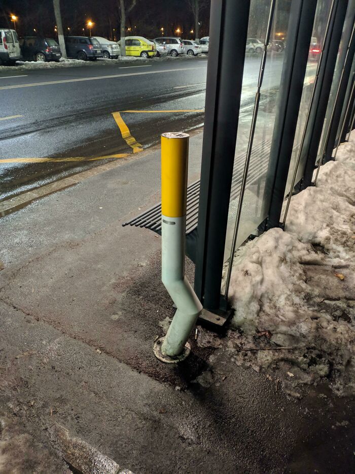 A bent bollard at a city sidewalk with snow, showcasing urban design errors, related to Cities-Genius-Solutions.