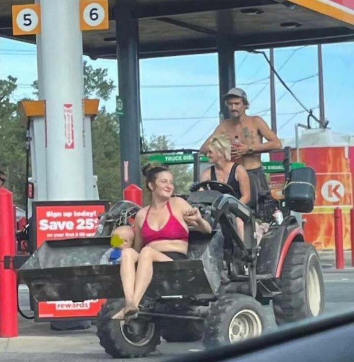 A unique Florida moment with people on a small vehicle at a gas station.