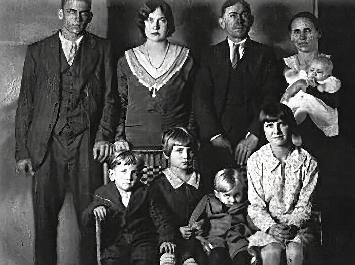A vintage family photo with a hidden terrifying backstory, showing three adults and four pixelated children.