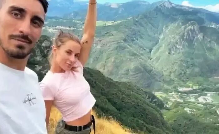 Couple taking a selfie on a mountain overlook, related to photographs with terrifying backstories.