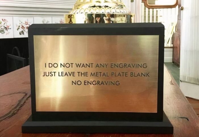 Trophy with an engraved plate reading, "I do not want any engraving, just leave the metal plate blank," illustrating hilarious misunderstandings.