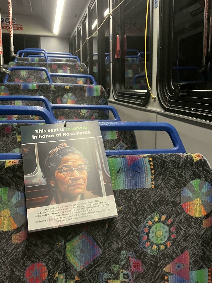 Bus seat reserved in honor of Rosa Parks with a colorful patterned interior, showing moderately interesting public transit detail.