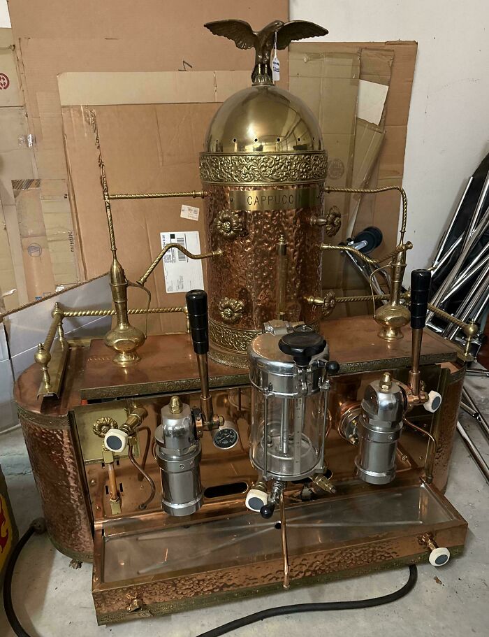 Vintage copper cappuccino machine with intricate design and eagle ornament, showing moderately interesting craftsmanship details.