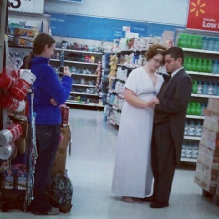 Couple posing for wedding photos in a store aisle, capturing a budget wedding moment.