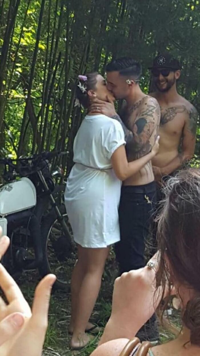 Couple kissing near a motorcycle during a casual outdoor wedding, capturing a budget-wedding-fail moment.