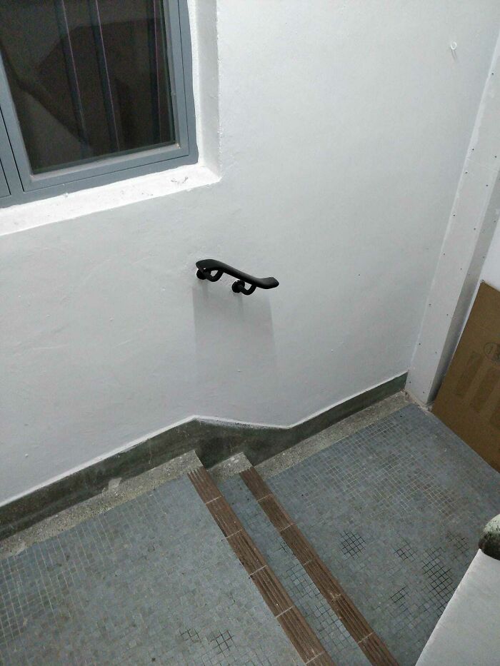 Steep, narrow stairs with a small handrail, emphasizing a potential safety hazard.