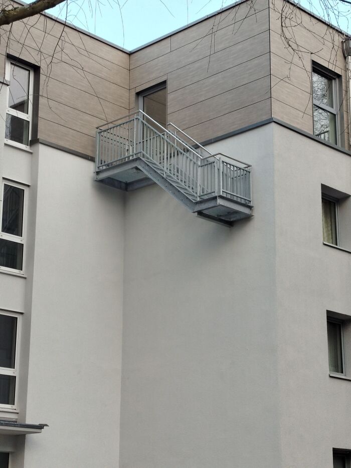 Outdoor staircase on a building leading to a closed door, illustrating the concept of "death stairs."