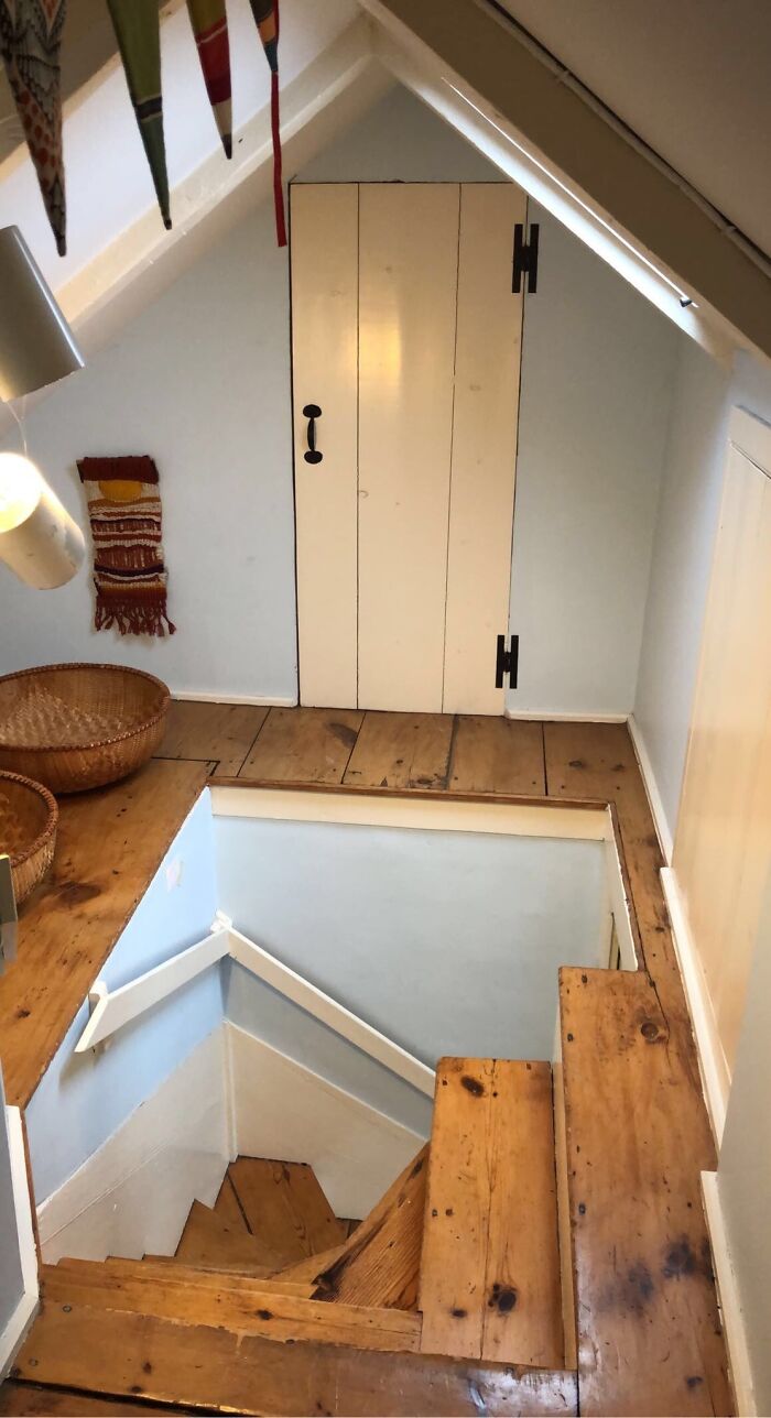 Steep narrow wooden stairs in a loft space, evoking the feel of "Death Stairs" due to their precarious design.