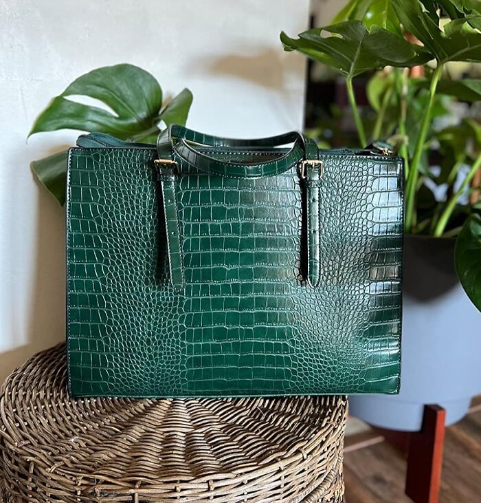 Dark green faux crocodile leather handbag on wicker stool, showcasing expensive taste with humble budget style accessory.