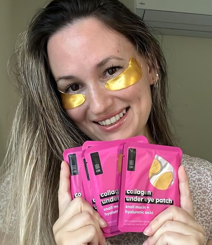 Woman wearing golden collagen under eye patches holding multiple pink collagen under eye patch packets, showcasing budget beauty finds