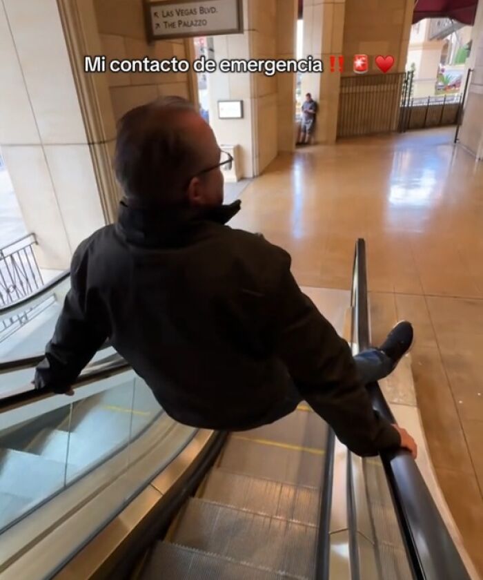Man sliding down an escalator handrail in a hotel lobby, displaying a humorous take on emergency handling.