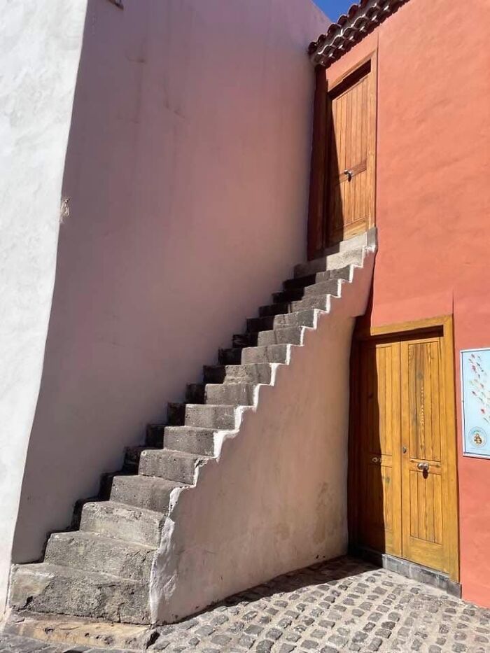 Stone stairs leading to a wooden door on a building, illustrating the concept of "death stairs."