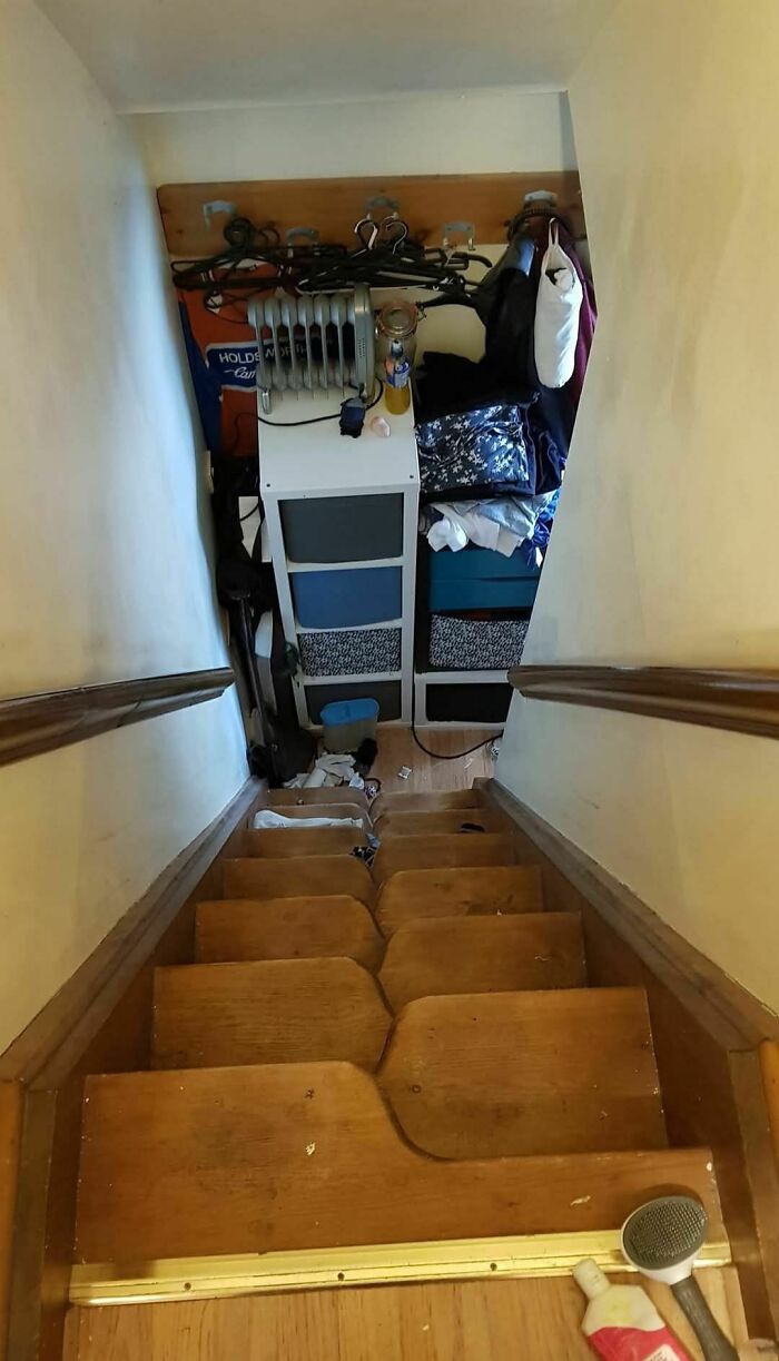 Cluttered and steep stairs, known as "death stairs," with narrow steps and obstructed path.